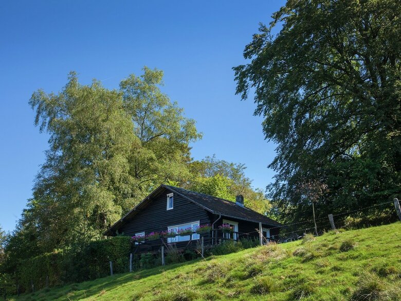 Open Wooden Chalet Built Against A Hill